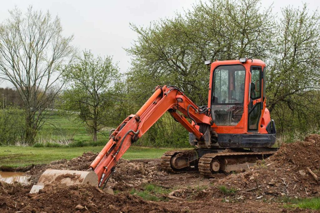 excavator digging a hole in backyard