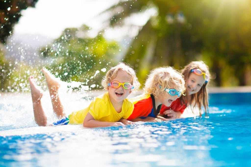 Children happily playing by the side of a plunge pool.