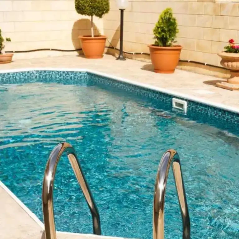 Custom concrete plunge pool with tiled finish and garden pots in private Grange courtyard