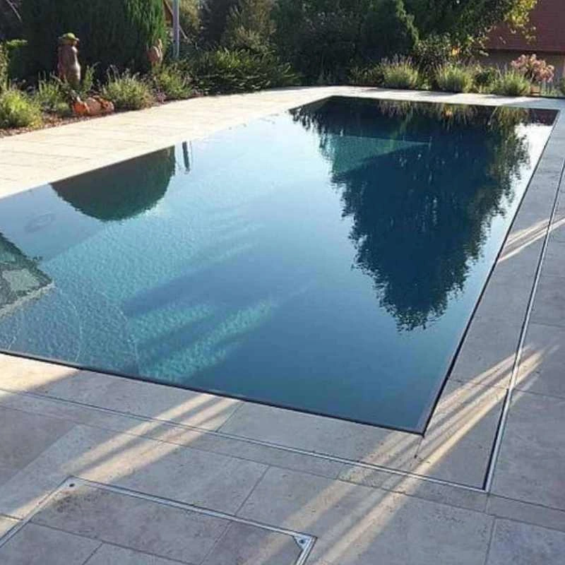 Infinity-style plunge pool with flush edges and modern stone paving in Camp Hill backyard