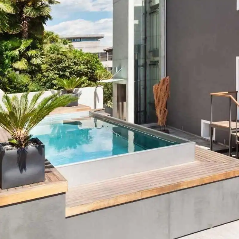 Semi above ground plunge pool with glass edge and modern outdoor design in Chelmer